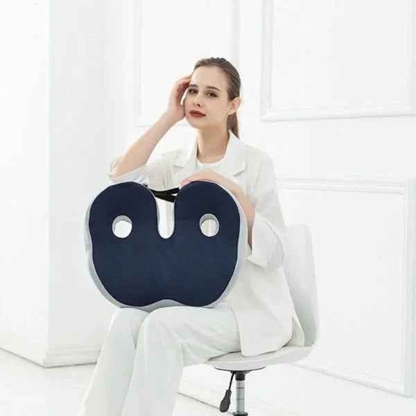 An image showing a woman in white holding a adjustable memory foam seat cushion against a white background.
