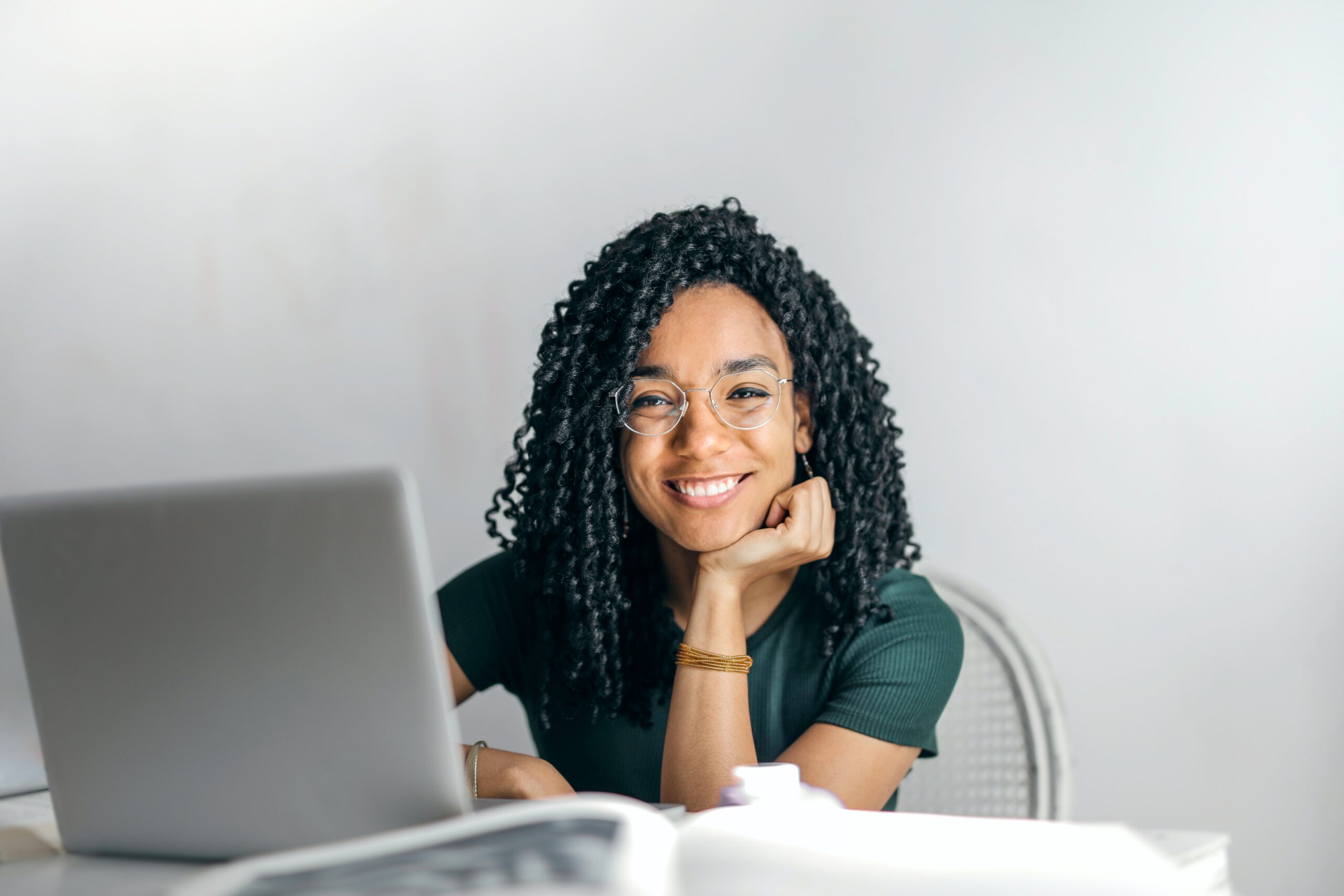 young-woman-with-glasses-smiling-in-front-of-laptop