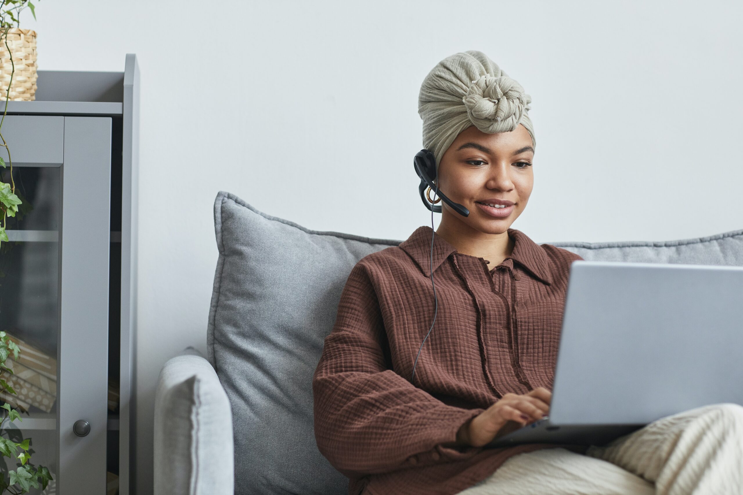 sitting-woman-with-headset-in-front-of-laptop