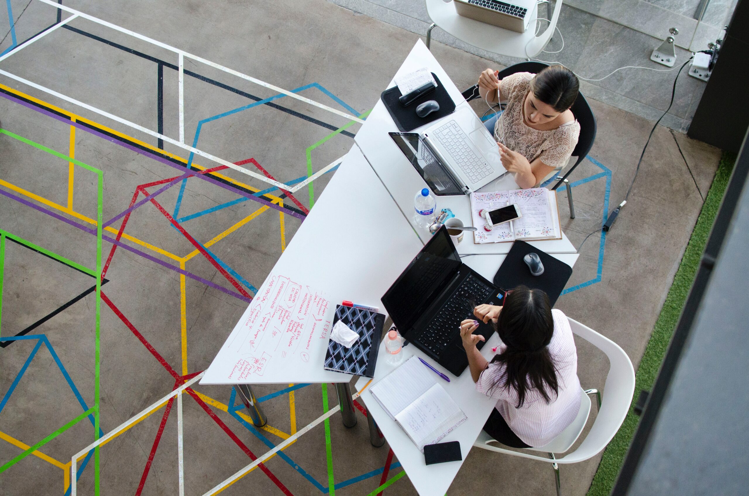 two-women-talking-in-front-of-laptop-in-white-table